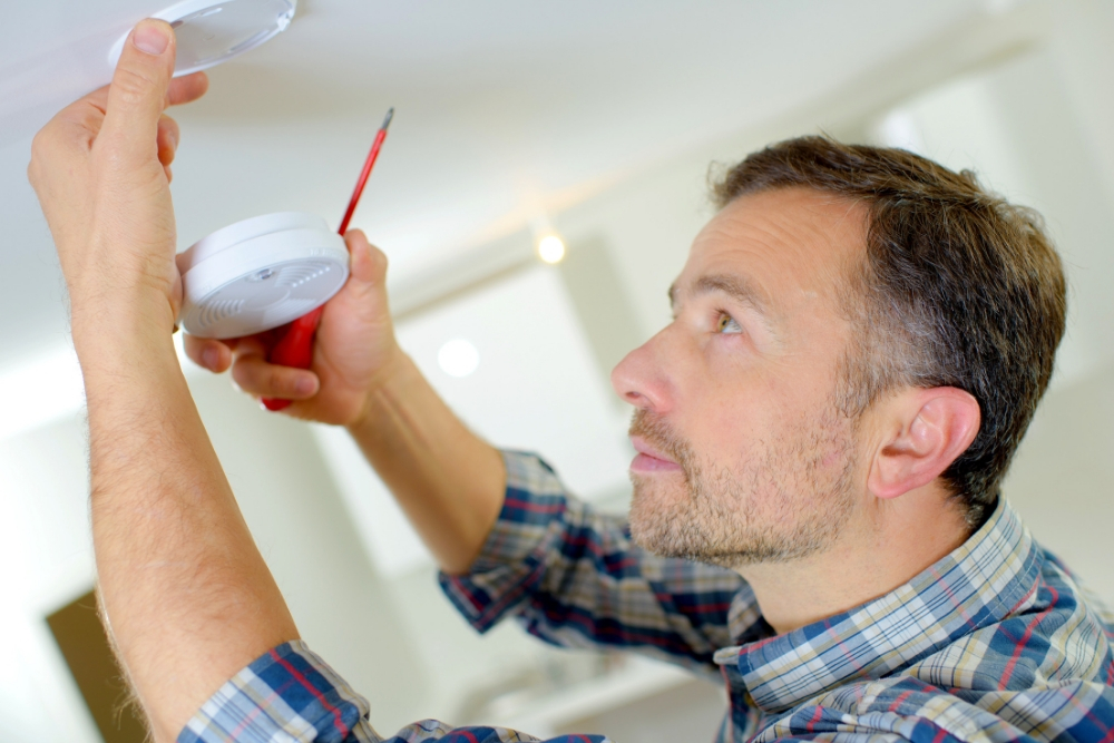 man-installing-smoke-detector-in-ceiling