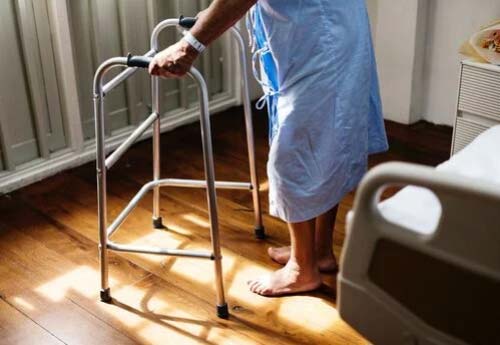 elderly person using walker with both hands